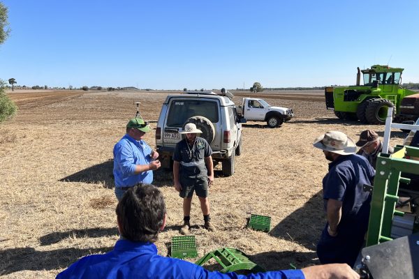 Kassie and grower in paddock discussing harvester set up